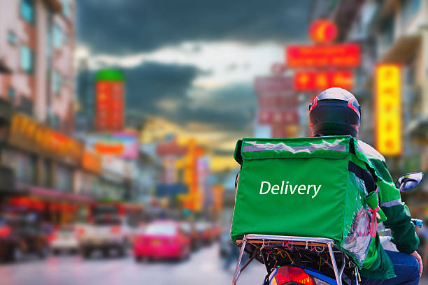 Bike courier riding through the city at dusk (16:9)