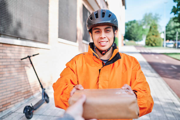 Rider handing a sealed parcel to a customer (16:9)
