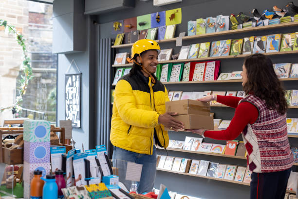 Boutique owner handing a parcel to a courier